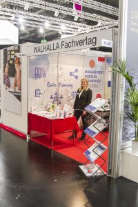ConSozial 2017: Eine Mitarbeiterin präsentiert den Stand des Walhalla Fachverlages freundlich
